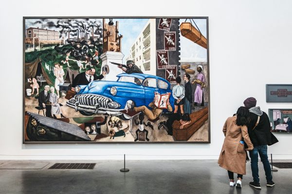 Visitors looking at a large contemporary painting on display at Tate Modern in London