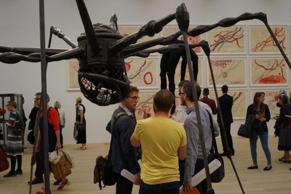 People viewing the giant spider sculpture by Louise Bourgeois at Tate Modern in London